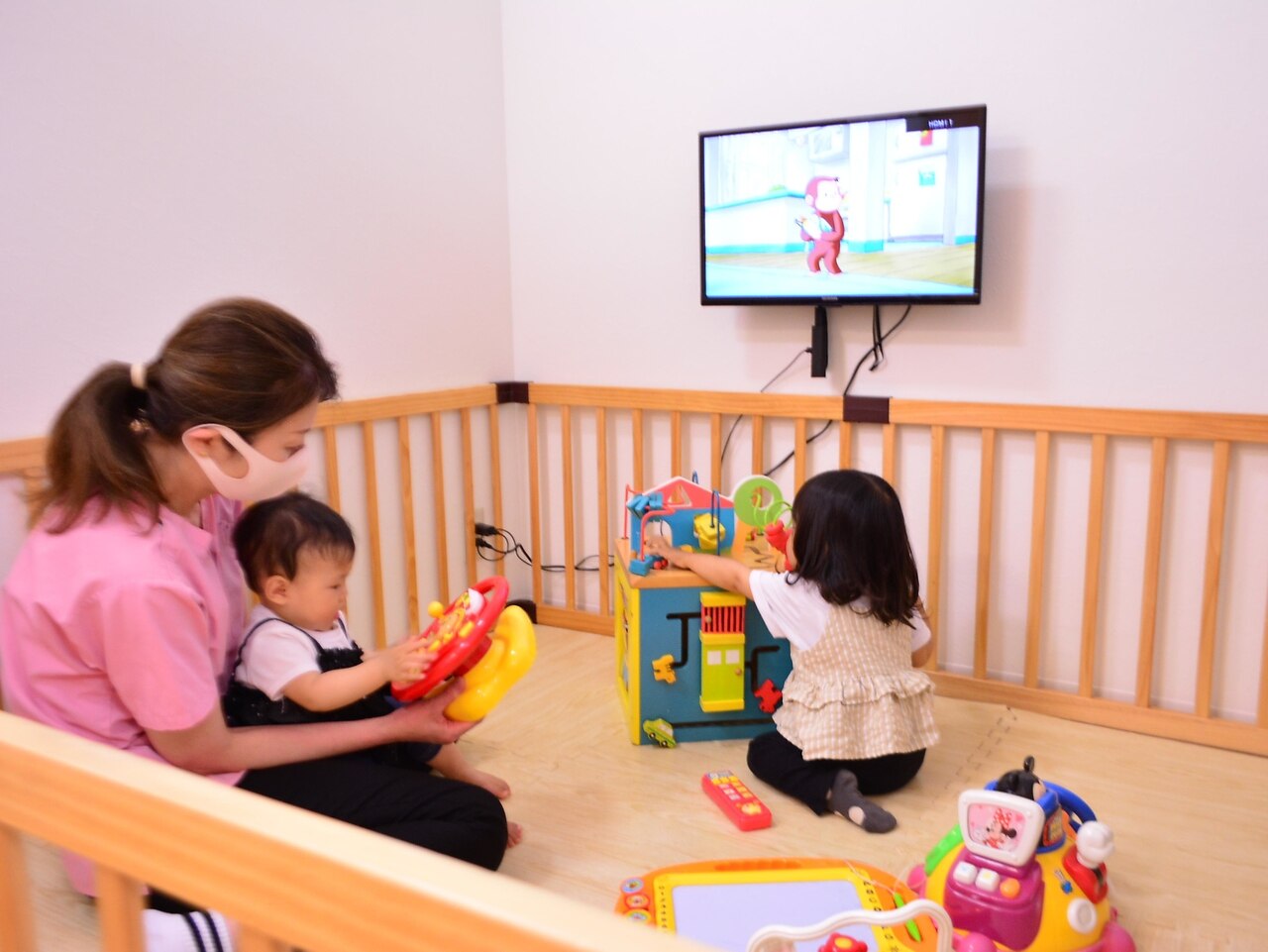 保育士がキッズスペースで赤ちゃんを見ている託児の様子